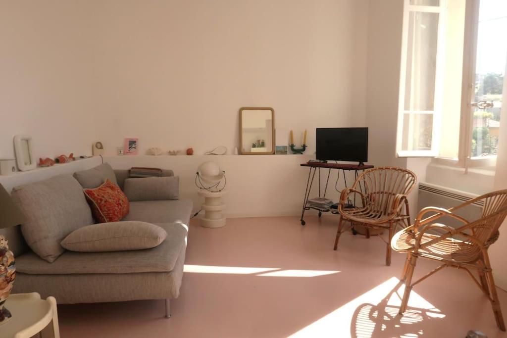 un salon avec un canapé, des chaises et une télévision dans l'établissement Maisonnette du Roucas, à Marseille