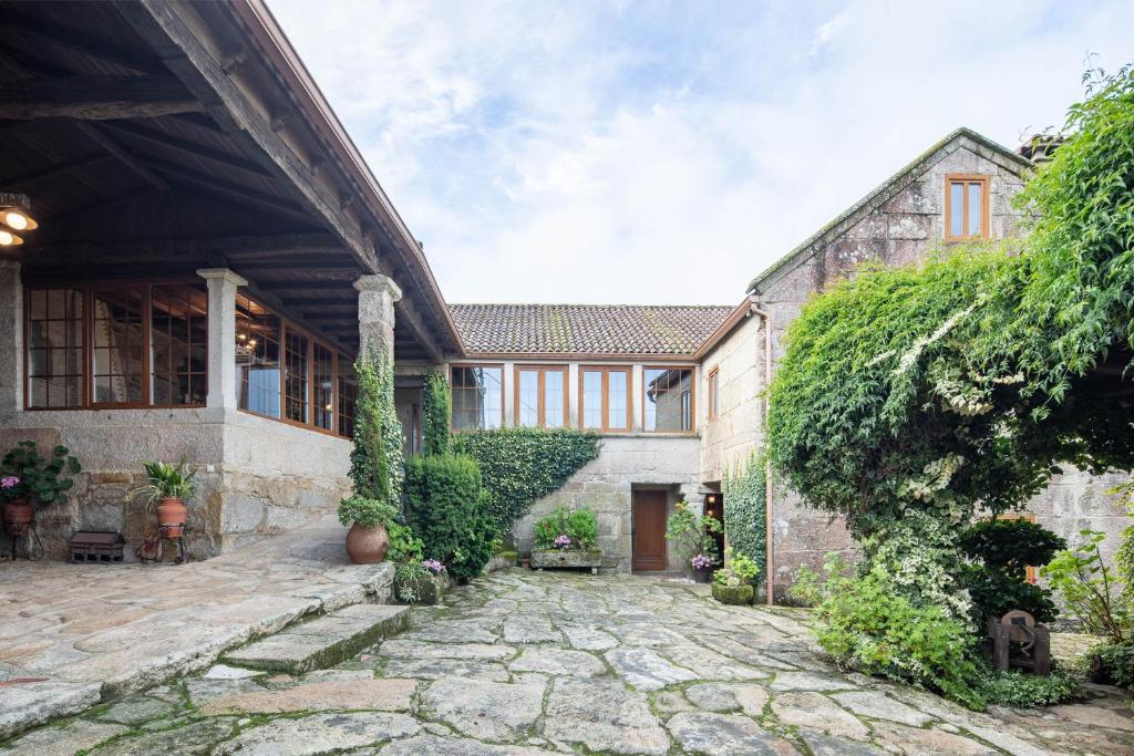 an exterior view of a house with a stone courtyard at Casa Rural Magina in Fornelos de Montes