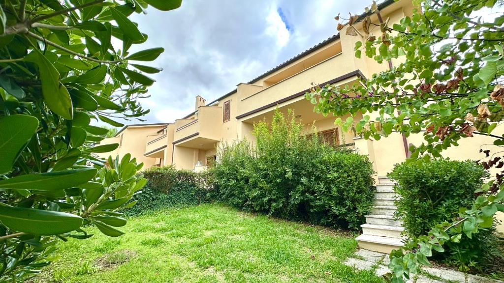 a building with a grass yard and stairs in front of it at Marcelli, trilocale con giardino a 200mt dal mare - M114 in Marcelli