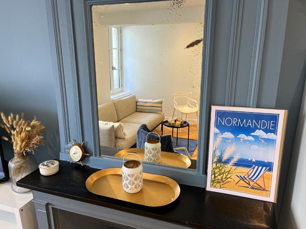 Cette chambre comprend un salon et une table avec un miroir. dans l'établissement Hyper centre - à 100m de la plage et 250m du casino, à Trouville-sur-Mer