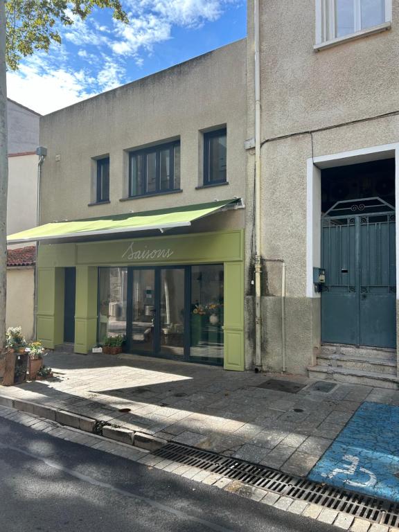 a store with a green awning in front of a building at Charmant studio en centre-ville in Céret