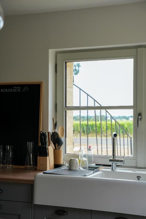 a kitchen with a window over a kitchen sink at Château Vieux Clos Saint Émilion in Saint-Émilion
