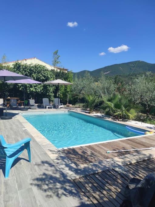 - une piscine dans un complexe avec une chaise bleue dans l'établissement Maison avec Jardin et Piscine privée, à Nyons