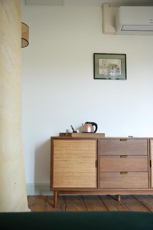 a wooden dresser in a room with a white wall at Château Vieux Clos Saint Émilion in Saint-Émilion