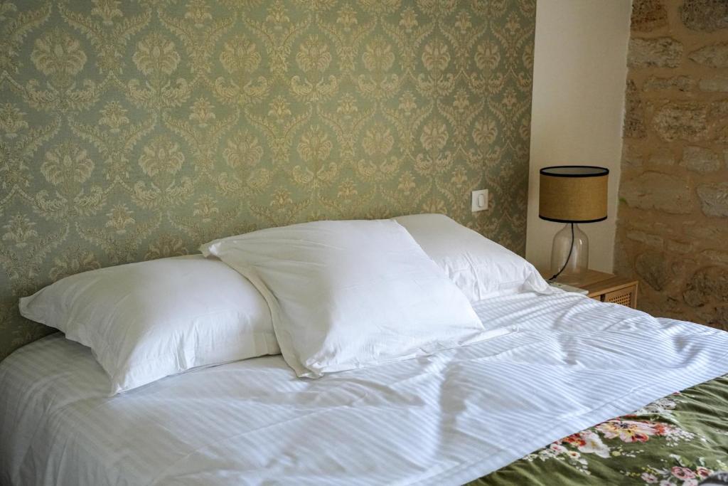 a bed with white sheets and pillows in a bedroom at Château Vieux Clos Saint Émilion in Saint-Émilion