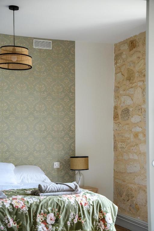 a bedroom with a bed and a stone wall at Château Vieux Clos Saint Émilion in Saint-Émilion