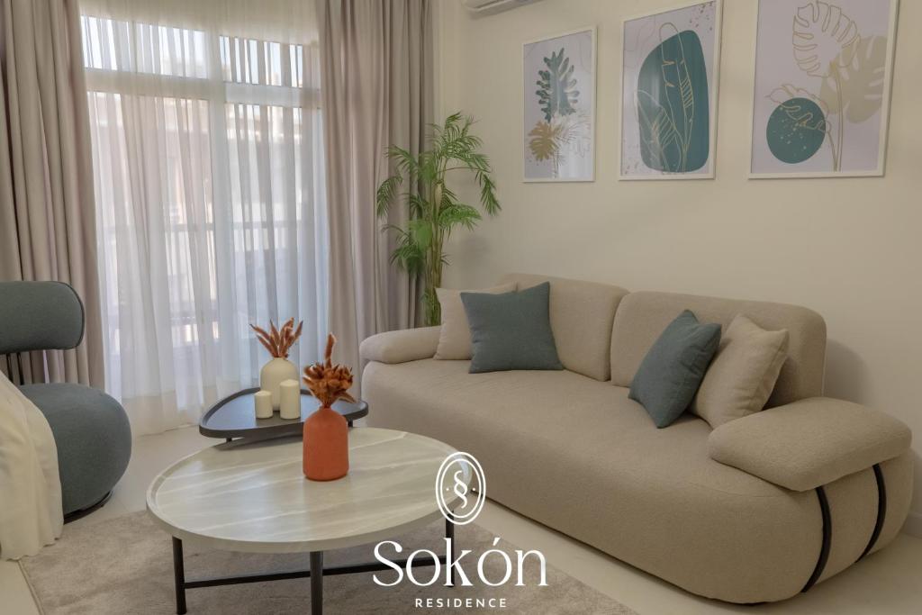 a living room with a couch and a table at Luxury 2BR City View Sokón R in Madinaty