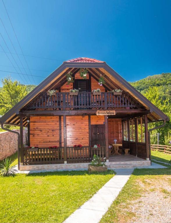 a log cabin with a porch and a balcony at Brvnara Sofiana in Bajina Bašta