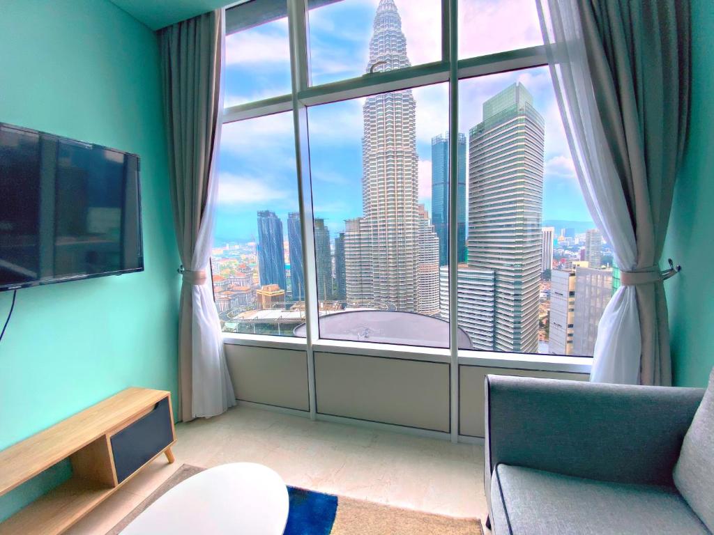 a room with a large window with a view of a city at Sky Suites KLCC BY Arman in Kuala Lumpur