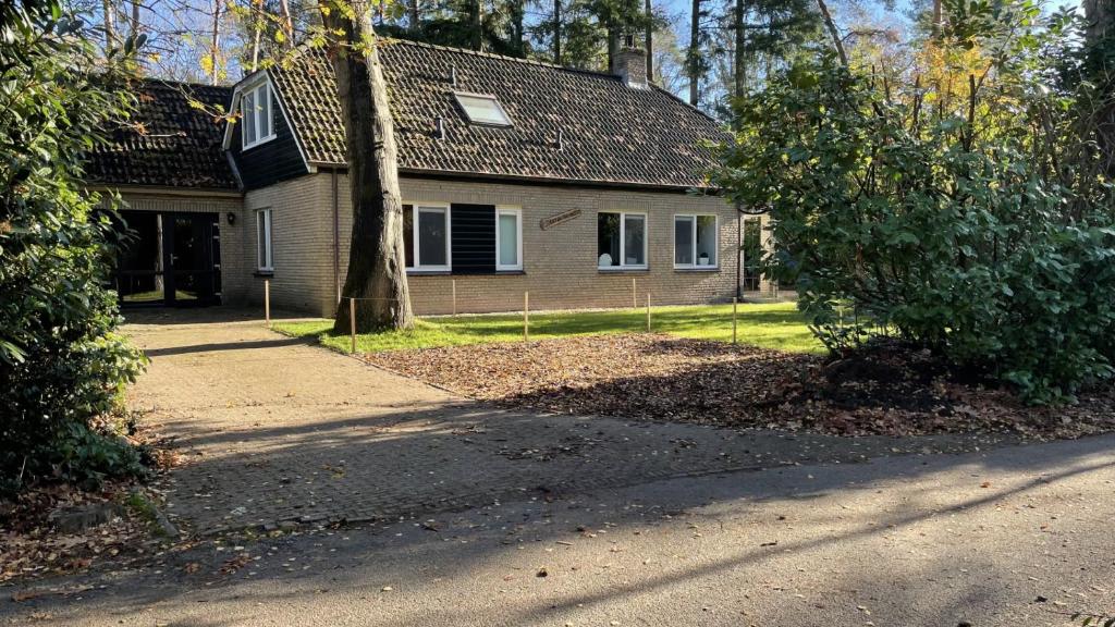 a house with a tree in front of it at Carpe Diem met bar biljart en sauna in Lochem