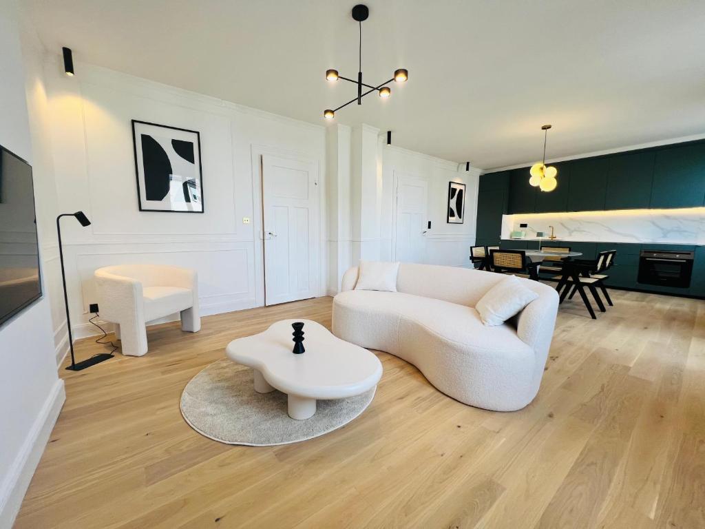 un salon avec un canapé blanc et une table dans l'établissement Le Notre-Dame, mon appartement Cosy et Elegant, à Strasbourg