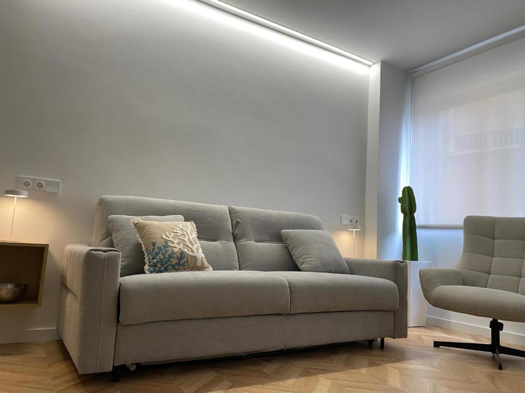 una sala de estar con un sofá y una silla en Luxury Gran Vía centro Murcia, en Murcia