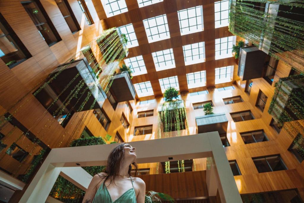 a woman looking up into a tall building at Radisson Blu Hotel & Spa, Istanbul Tuzla in Istanbul