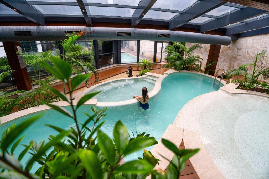 a woman in a swimming pool in a building at Radisson Blu Hotel & Spa, Istanbul Tuzla in Istanbul