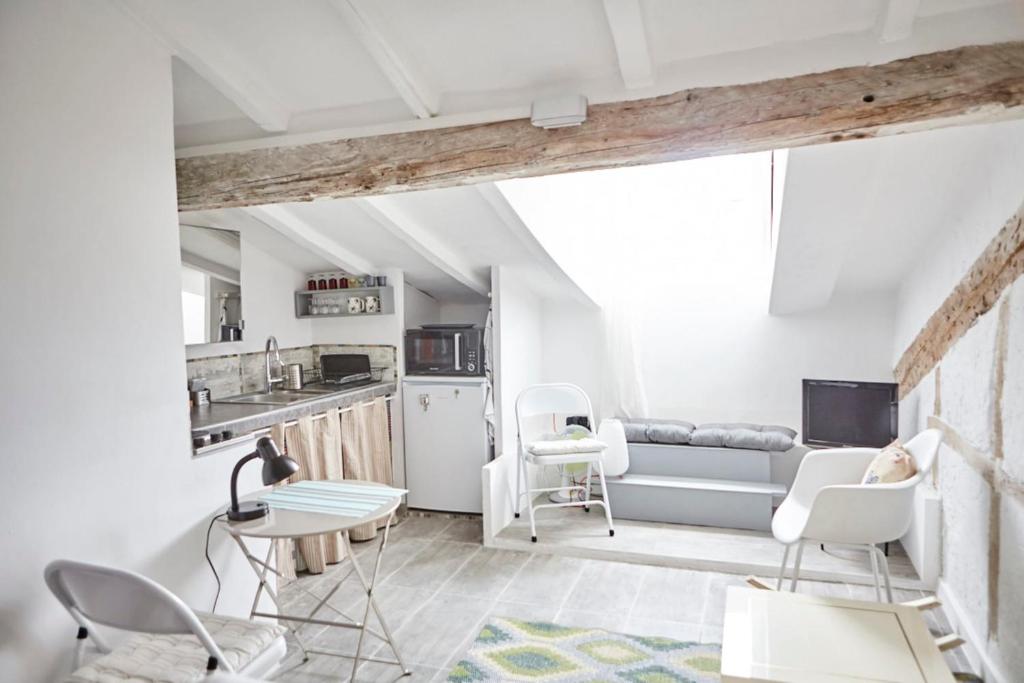 Il comprend une cuisine et un salon avec des chaises et une table. dans l'établissement Studio Côte Blanche - Welkeys, à Nice