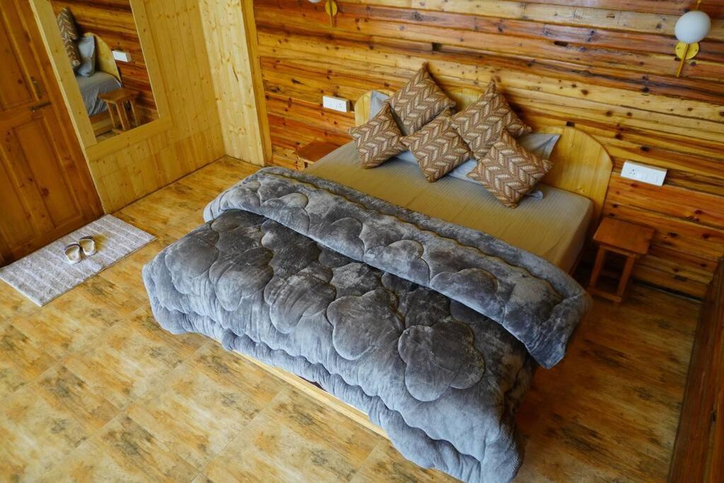 Postel nebo postele na pokoji v ubytování Winterfell Log House Jibhi - With Jacuzzi