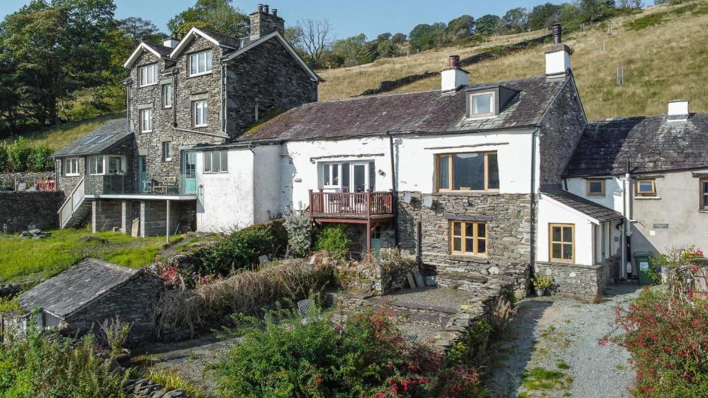 una casa vieja al lado de una colina en Longmire Yeat Cottage, en Troutbeck