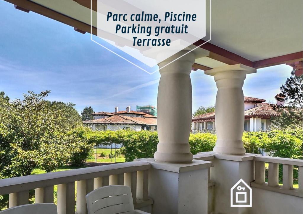 un balcon avec des chaises et une balustrade avec les mots prairie colina parking pique-nique dans l'établissement Hasparren-121 T2 terrasse et piscine, à Urrugne