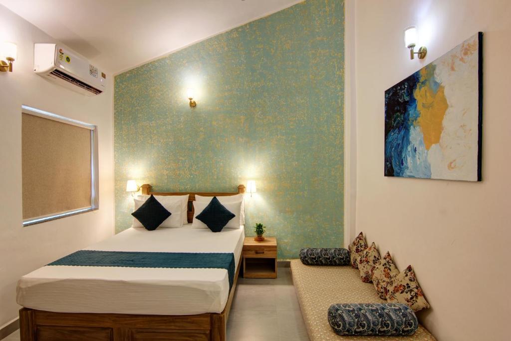a bedroom with two beds and a chair in it at Comfort Holiday Home in Baga