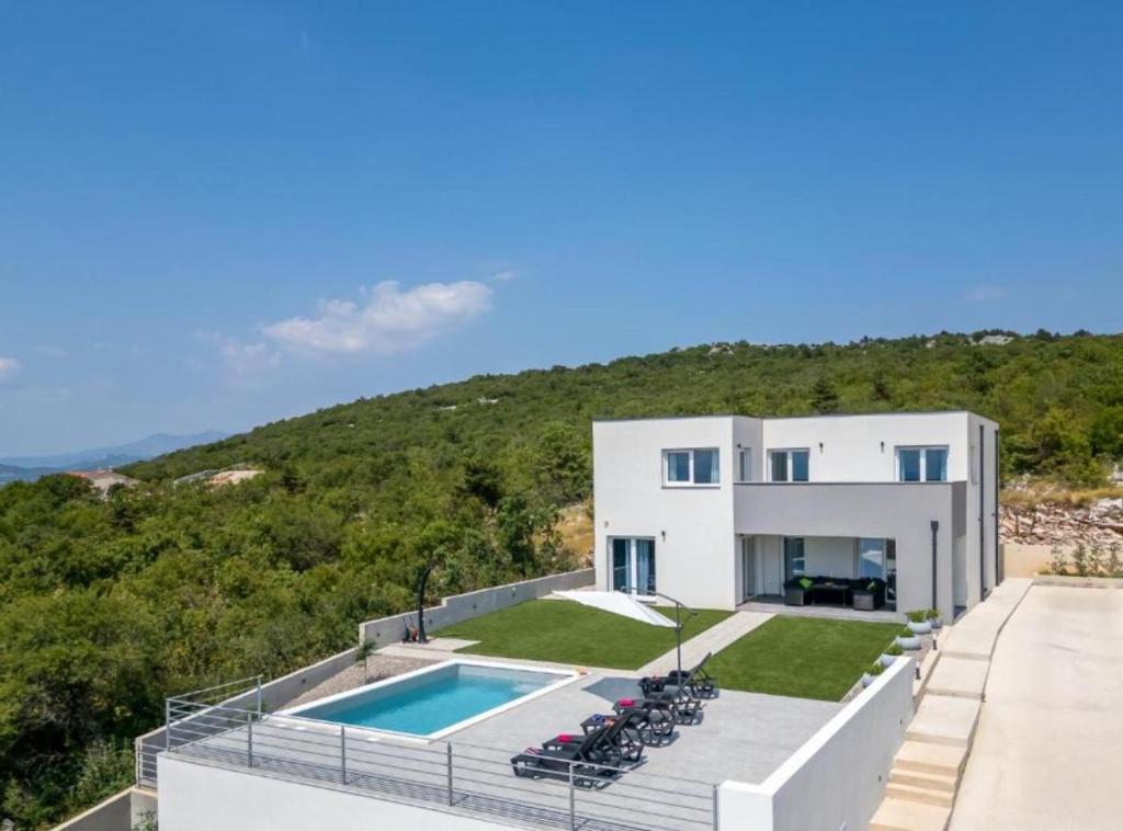 a villa with a swimming pool on a hill at Villa Fran in Šmrika