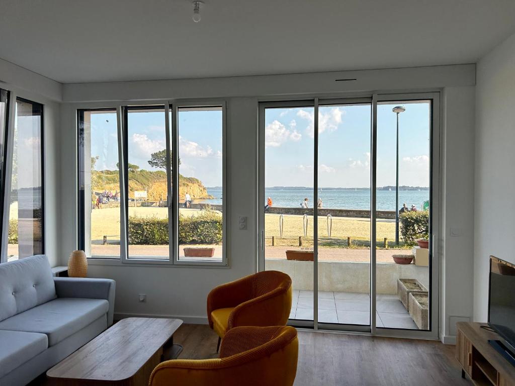 Una sala de estar con sofá y vistas al océano. en Bel Appartement face mer, en Billiers