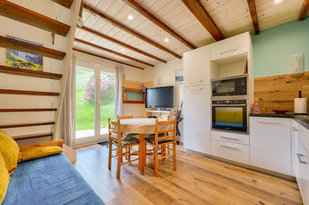 una cucina e una sala da pranzo con tavolo e sedie di Chalet pour 6 avec terrasse - 400m des pistes a Val-Louron