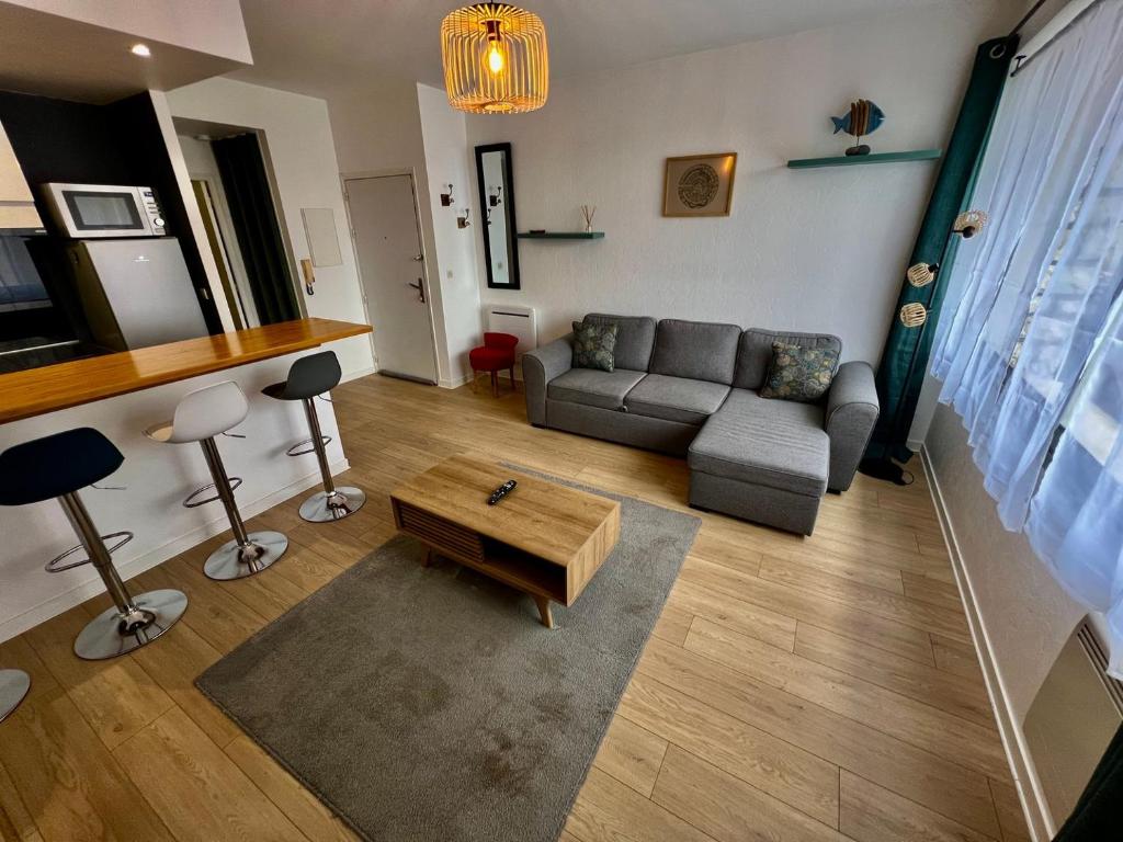 un salon avec un canapé et une table basse dans l'établissement Le Saint-Hilaire - appartement calme + parking, à Poitiers