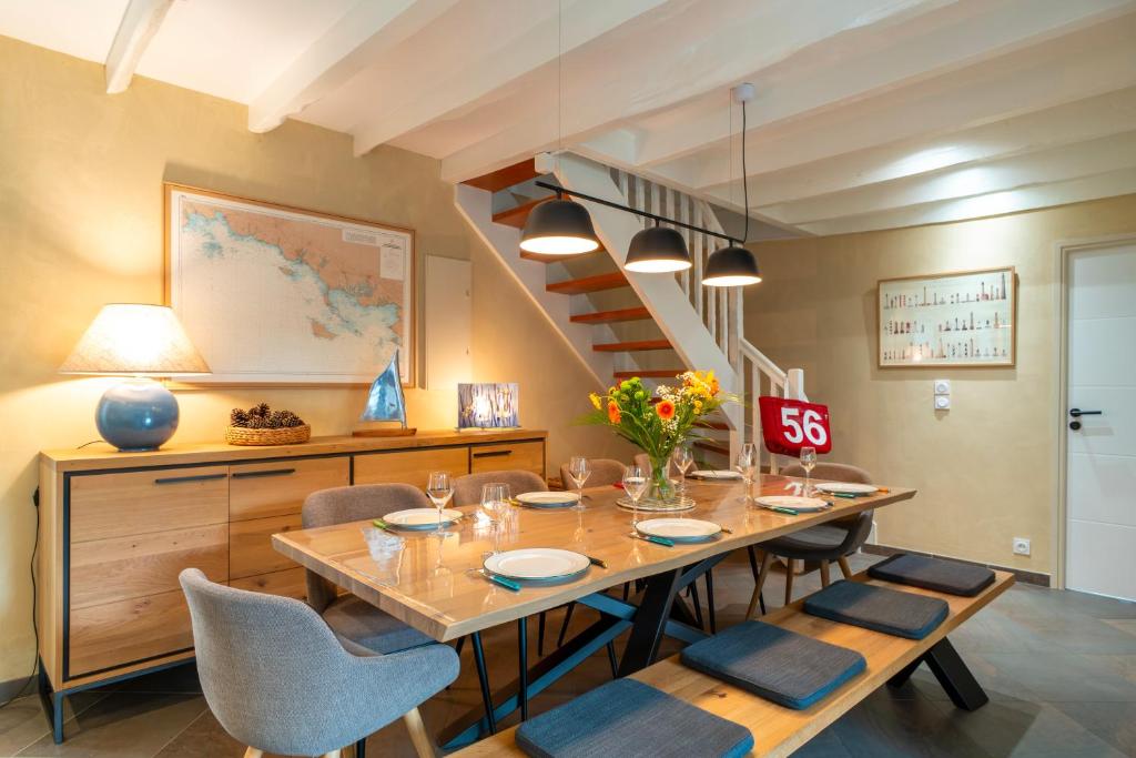 une salle à manger avec une table et des chaises et un escalier dans l'établissement TY ELISTHER - Maison de charme à Saint-Colombier, à Sarzeau