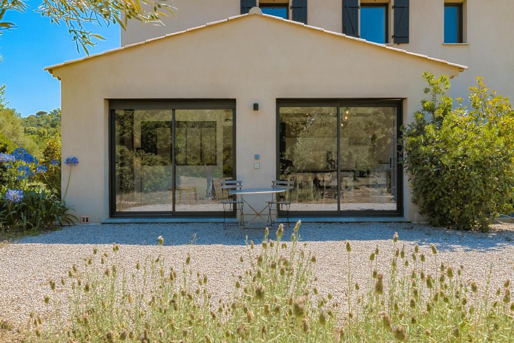 une maison avec de grandes fenêtres dans un jardin dans l'établissement L'atelier, à Saint-Tropez
