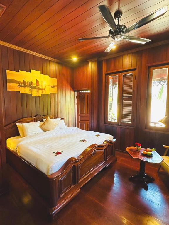 a bedroom with a bed and a ceiling fan at Luang Prabang Mekong Charm River View in Luang Prabang