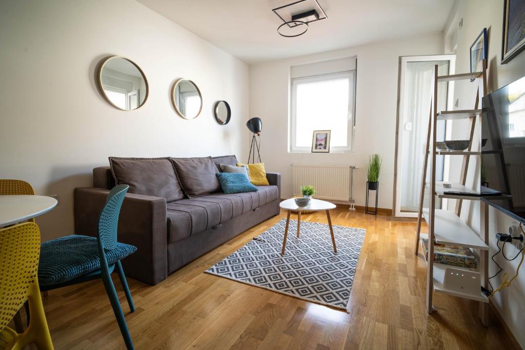 una sala de estar con un sofá y una mesa en Apartment sPARK Niš, en Niš