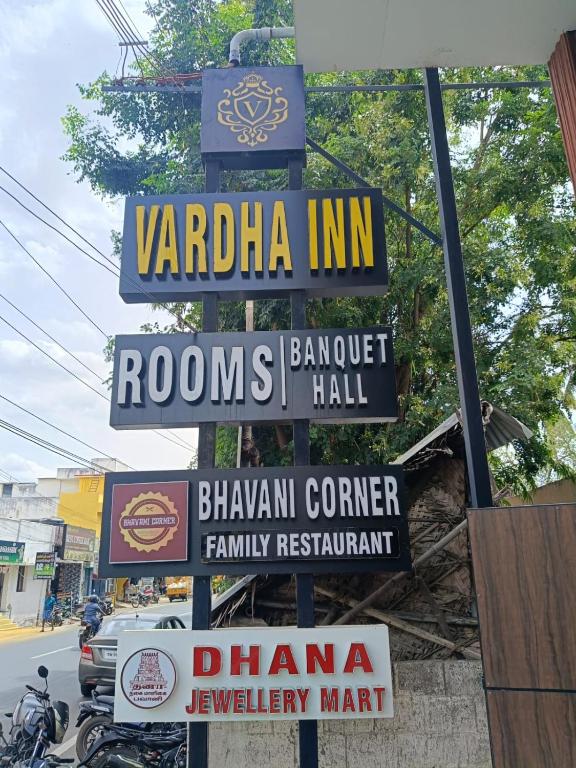 a bunch of signs on a pole on a street at HOTEL VARDHA Inn in Bhavāni