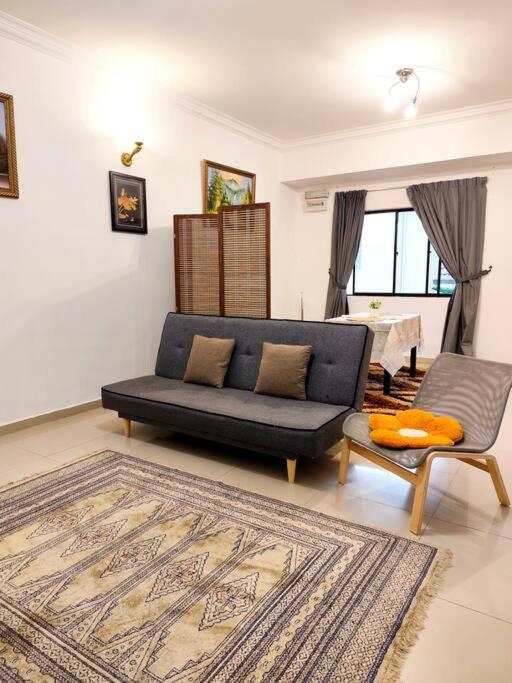 a living room with a blue couch and a chair at Bukit Cottage - bungalow style in Tanah Rata