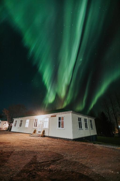 a building with the aurora in the sky at Bjork Guesthouse in Laugarvatn