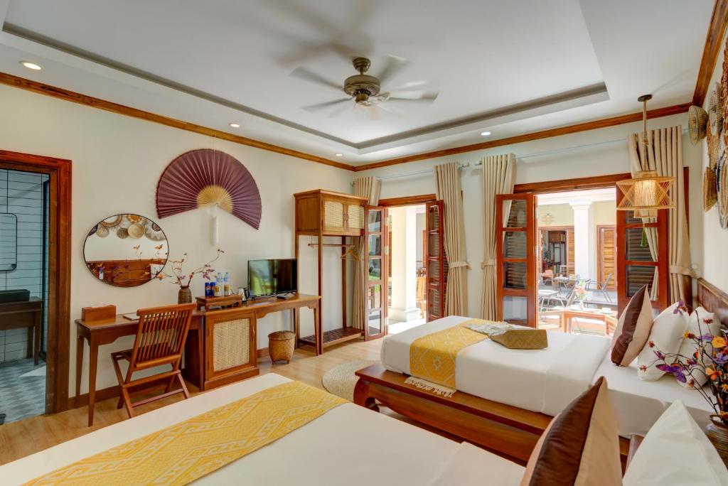 a bedroom with a bed and a desk at Elegant Boutique Hotel Luangprabang in Luang Prabang
