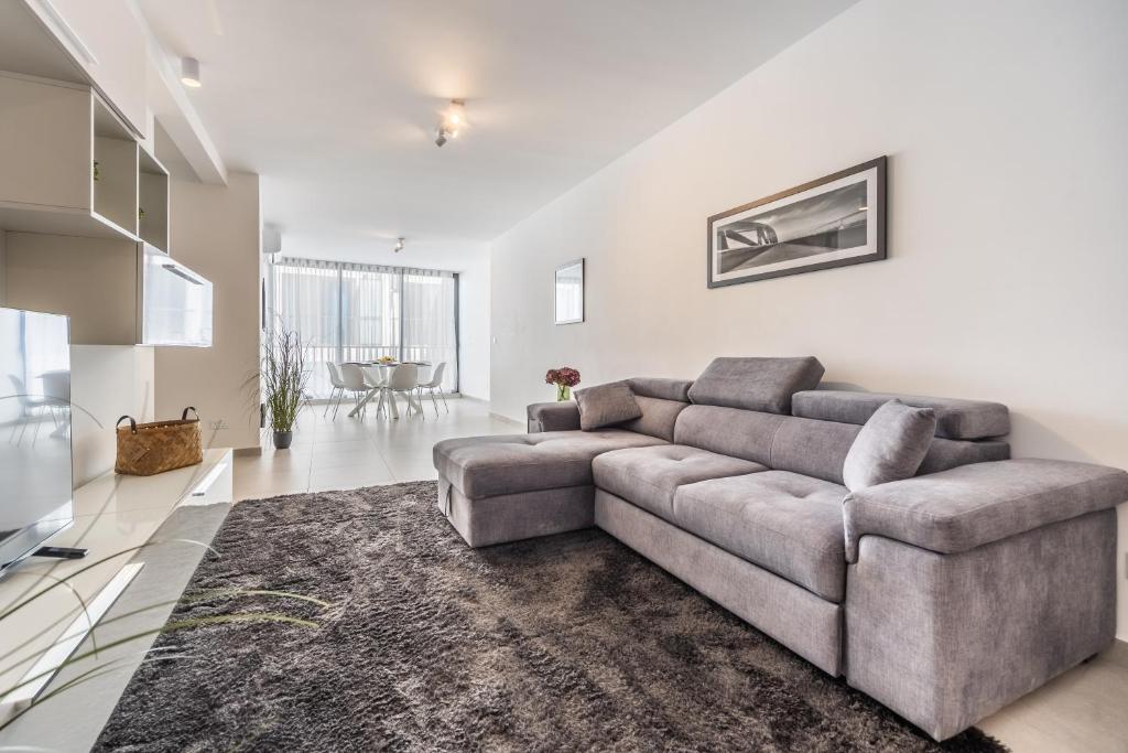 un soggiorno con un divano e un tavolo di Chic Downtown Hideaway a Msida