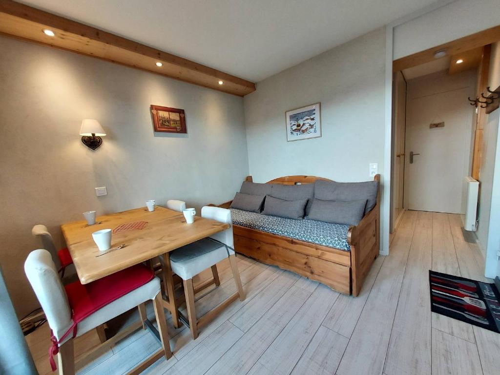 Cette chambre comprend une table, un canapé, une table et des chaises. dans l'établissement Charmant 2P 4 pers, quartier central, proche commodités et pistes - FR-1-353-133, à La Plagne Tarentaise