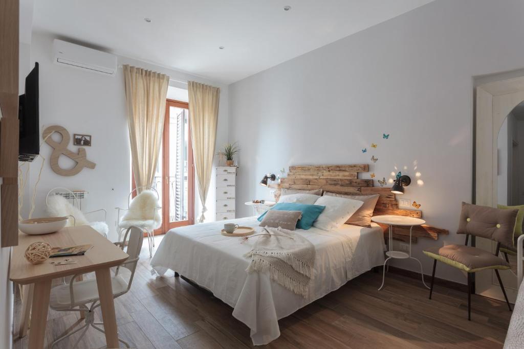 ローマにあるMaison Coquetteの白いベッドルーム(ベッド1台、テーブル、椅子付)
