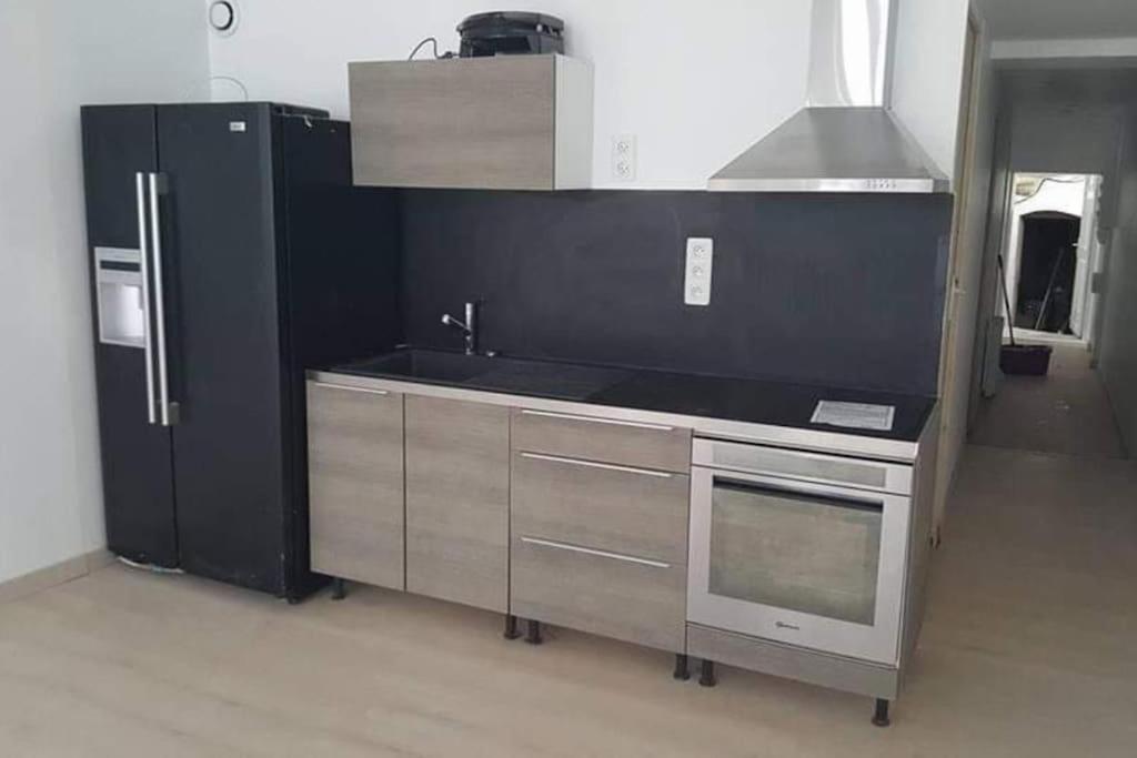 une cuisine avec un évier et un réfrigérateur dans l'établissement F3 centre ville Baume les dames, à Baume-les-Dames