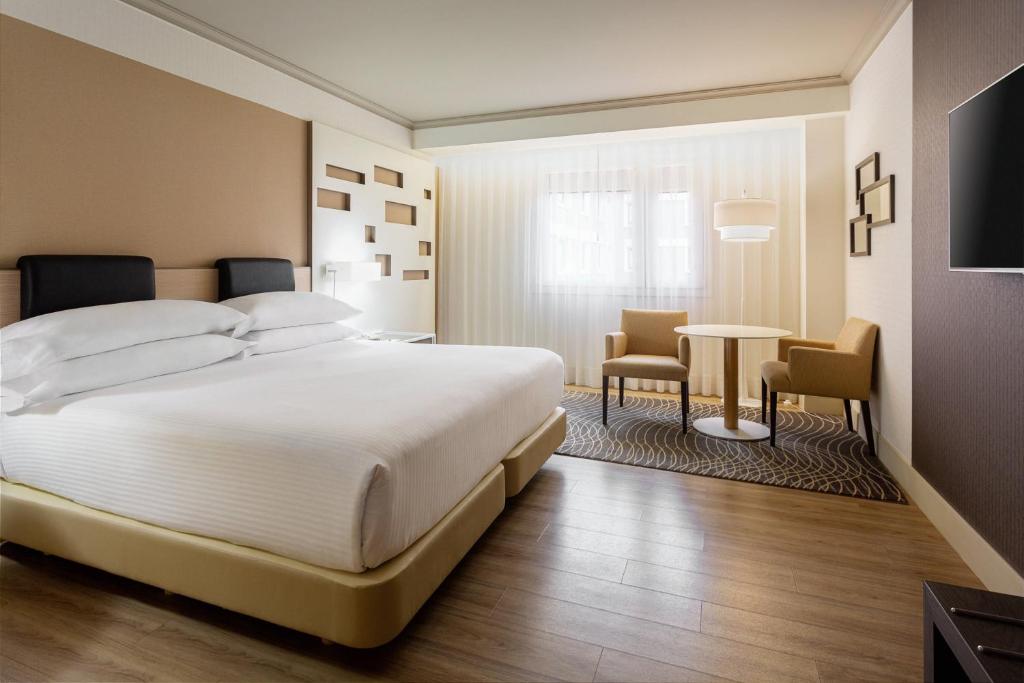 A bed or beds in a room at Madrid Marriott Auditorium Hotel & Conference Center