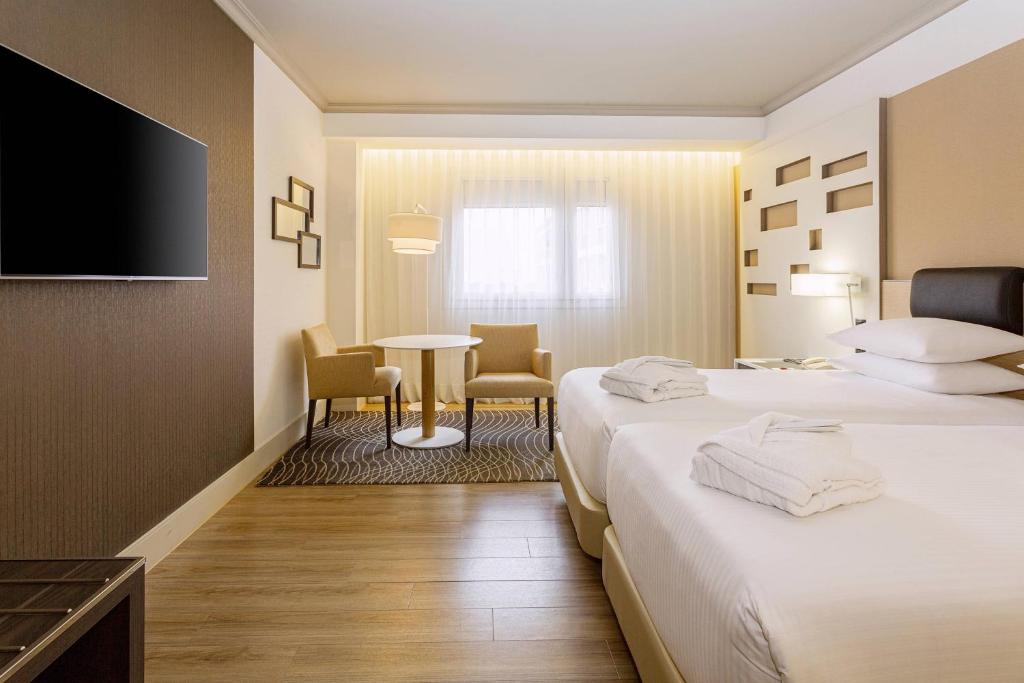 A bed or beds in a room at Madrid Marriott Auditorium Hotel & Conference Center