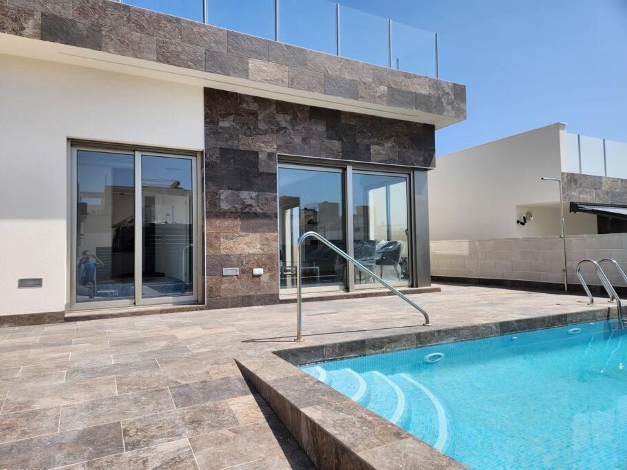 a swimming pool in front of a house at Fee4Me Villa, Pool, Roofterrace & Relax in Alicante