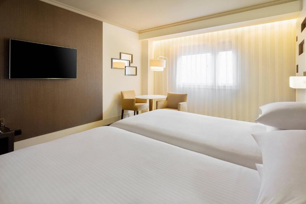 A bed or beds in a room at Madrid Marriott Auditorium Hotel & Conference Center