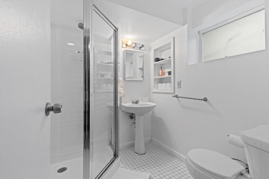 a white bathroom with a shower and a sink at Cozy 1-bedroom garden apartment in Silver Spring