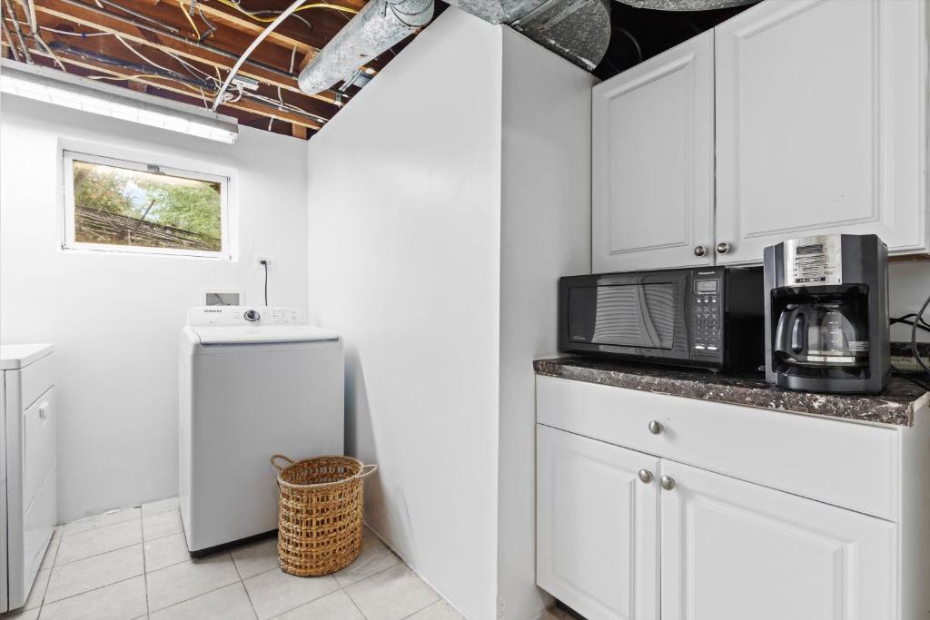 a kitchen with a microwave and a refrigerator at Cozy 1-bedroom garden apartment in Silver Spring