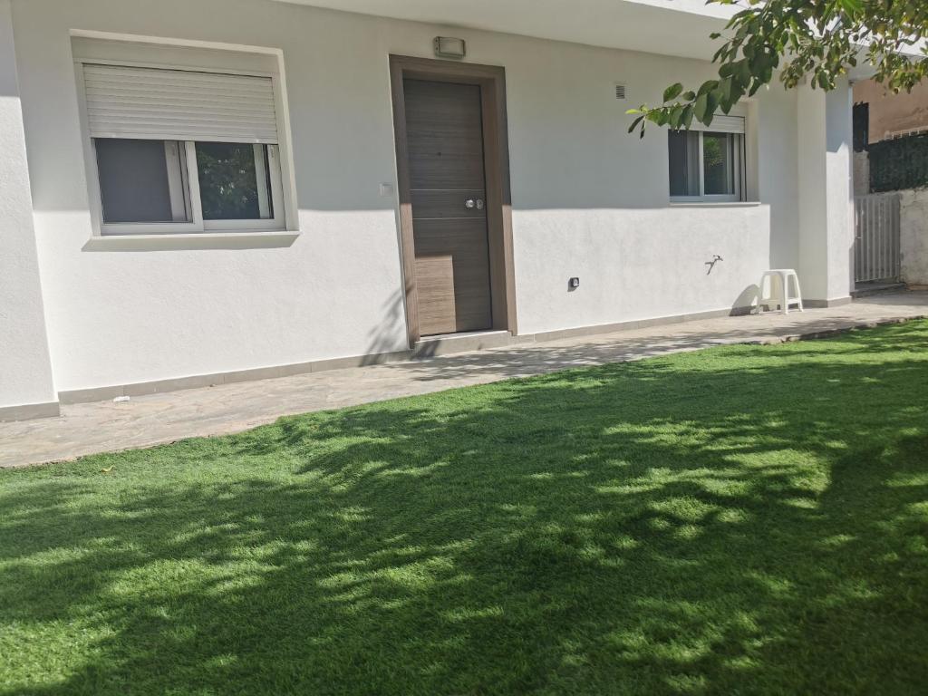 een huis met een groen gazon ervoor bij GardenHouse in Athene