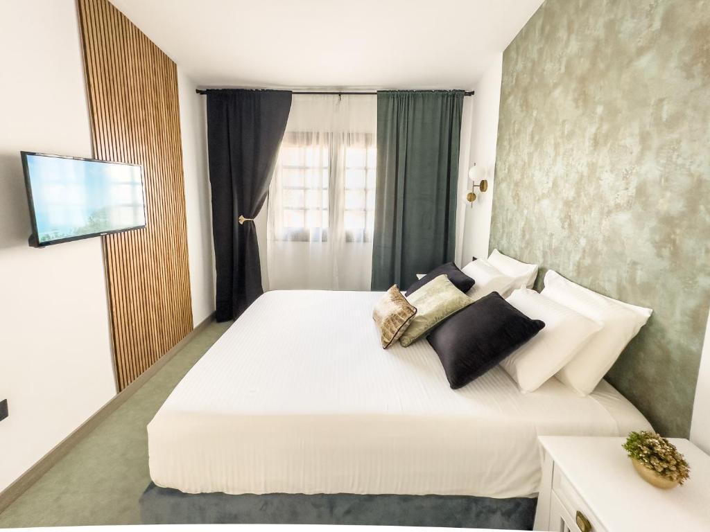 a bedroom with a large white bed with pillows at Infinity Ocean View Suite in Adeje
