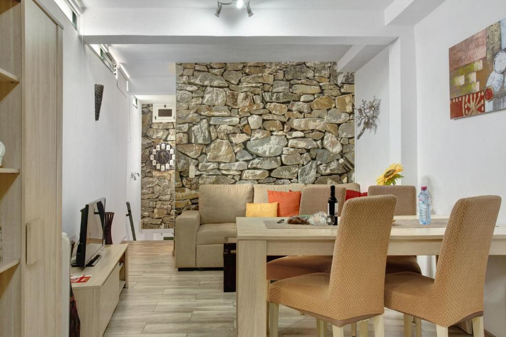 a living room with a table and a stone wall at Host Albina in Funchal