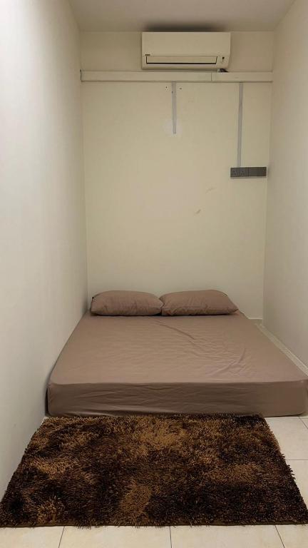 a bed in a room with a white wall at Kiki's room for men 8B in Melaka