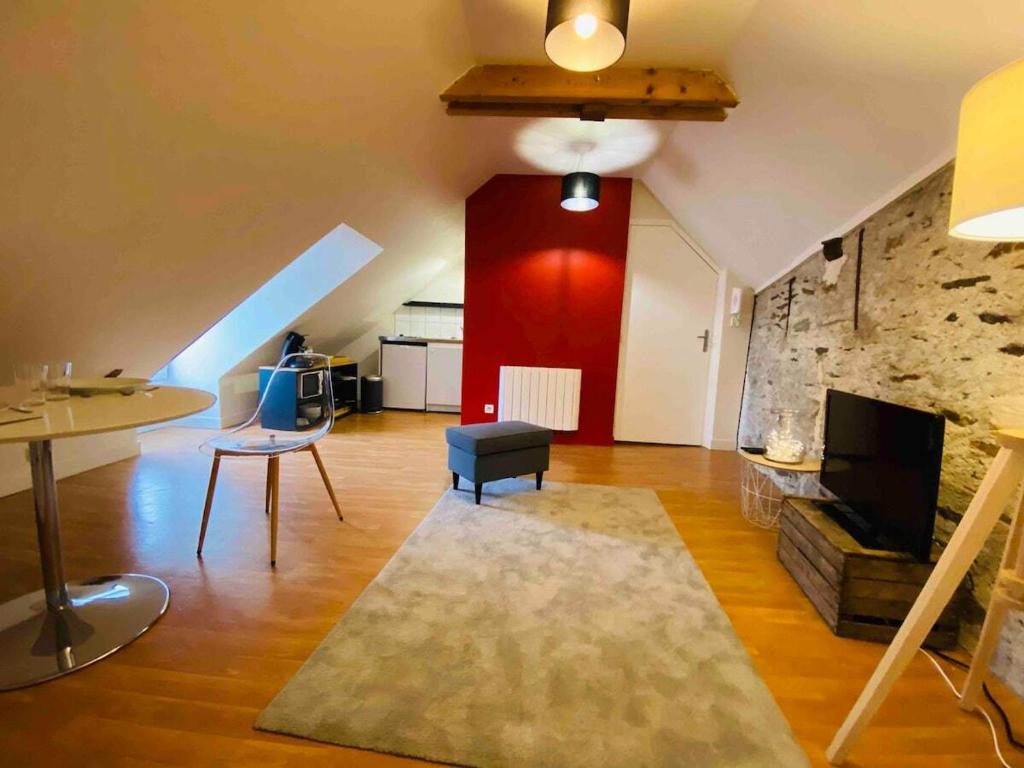 un salon avec un canapé, une télévision et une table dans l'établissement Casa Ma Maine, à Bouchemaine